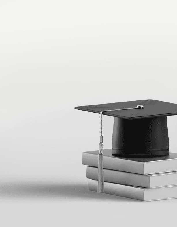Black graduation cap with tassel resting on a neat stack of three closed books against a plain light background.