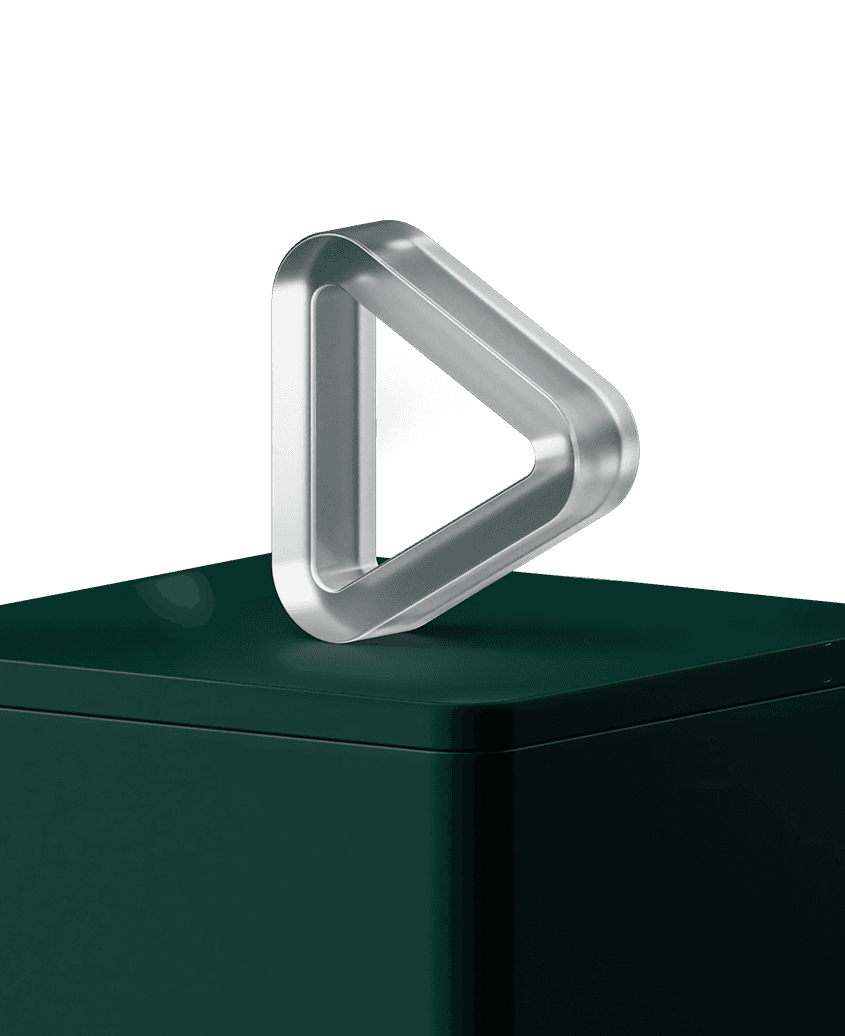 Silver triangular play-shaped metal sculpture on a dark green pedestal against a minimal background.