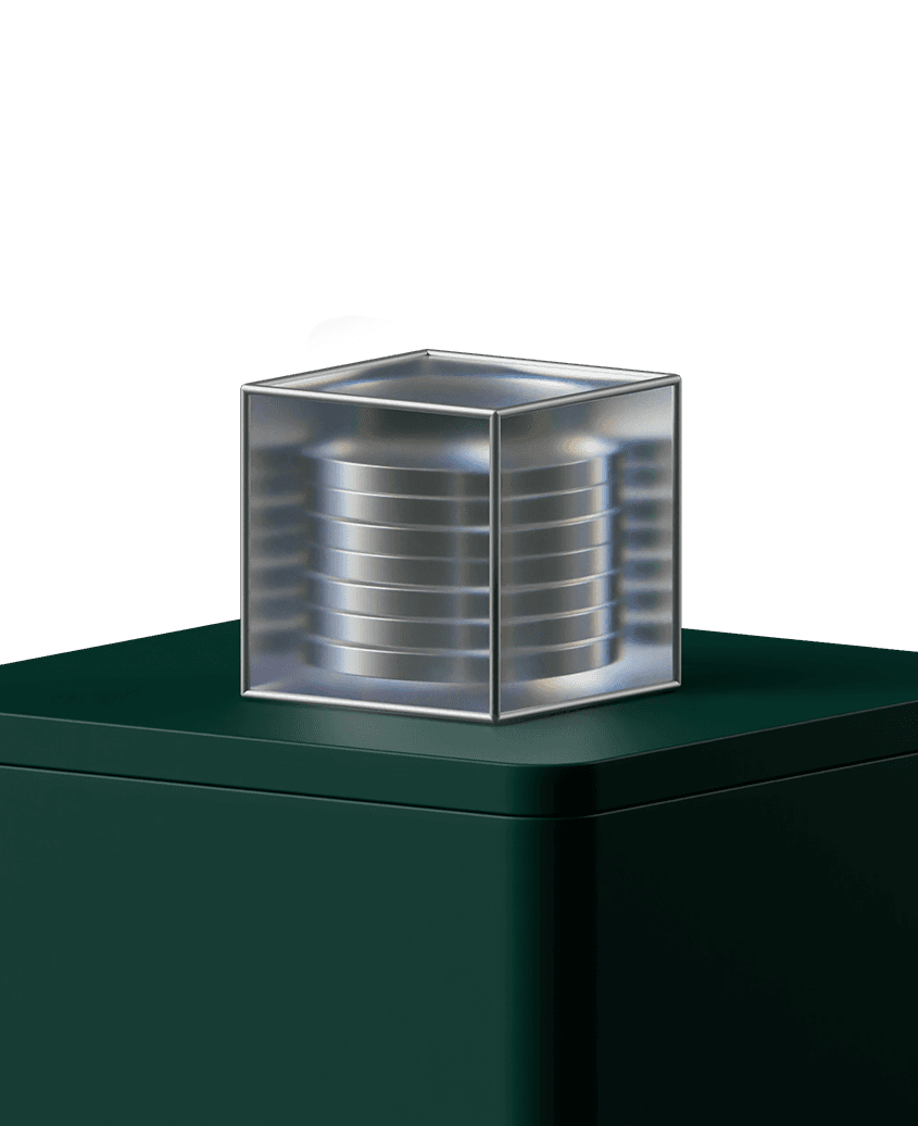 Transparent cube container holding stacked metallic discs, placed on a dark green rectangular pedestal against a neutral background.
