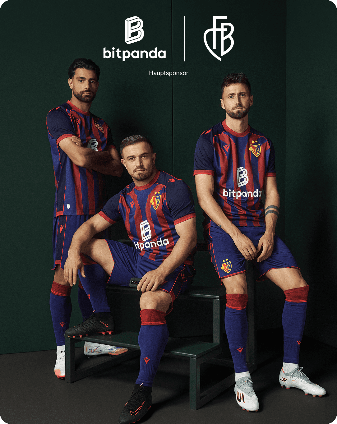 Three soccer players in red and blue striped uniforms pose confidently in front of a dark green background with Bitpanda and FC Basel logos.