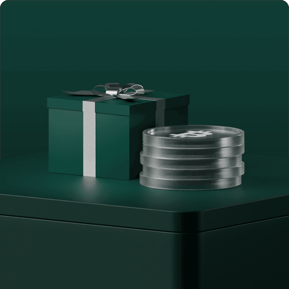 Green gift box with silver ribbon beside a stack of round, transparent containers on a matching green surface.