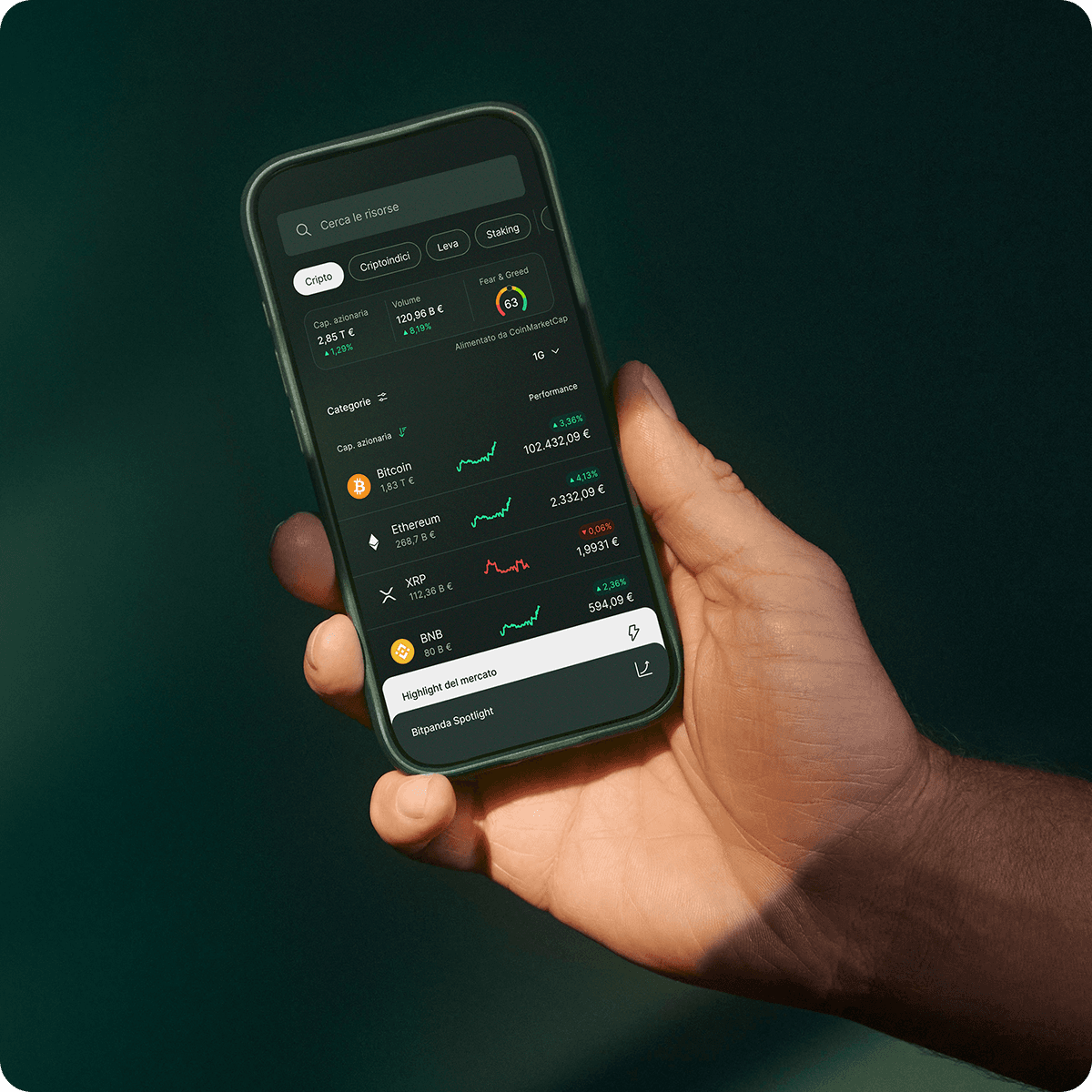 Hand holding a smartphone displaying a cryptocurrency tracking app with various coin prices and graphs against a dark background.